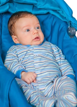 Portrait of a 2 months old baby boy sitting in a safety seat.