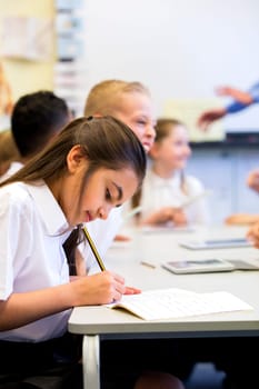Schoolgirl sits at her desk while working .