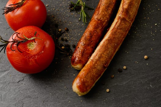 Roasted tomatoes with rosemary and grilled sausages