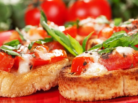 Bruschetta with tomato and mozzarella cheese, decorated with basil