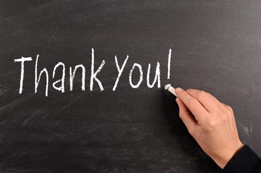 Hand writing with chalk Thank You! on a blackboard