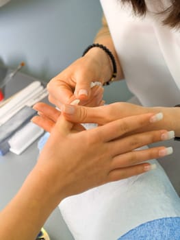 Girl fingernails being manicured.