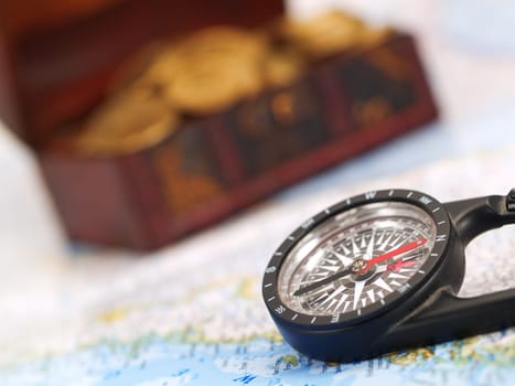 Treasure chest with gold coins, ocean map and a compass