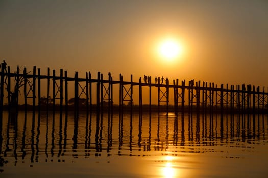 U Bein Bridge at sunset with people crossing Ayeyarwady River, Mandalay, Myanmar