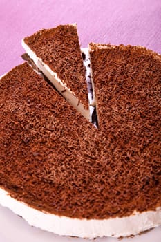 Chocolate cheesecake with one piece cut