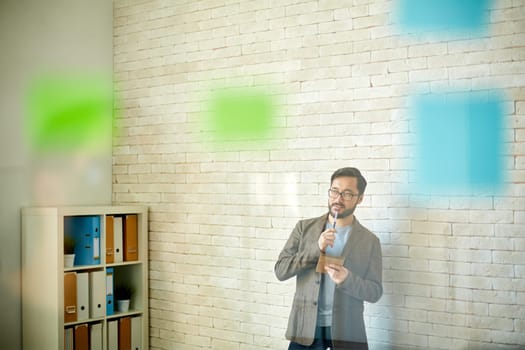 Pensive businessman with notepad working in office