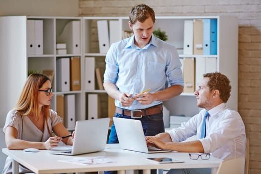 Confident co-workers discussing plans in office