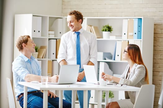 Happy business partners talking at break between working hours