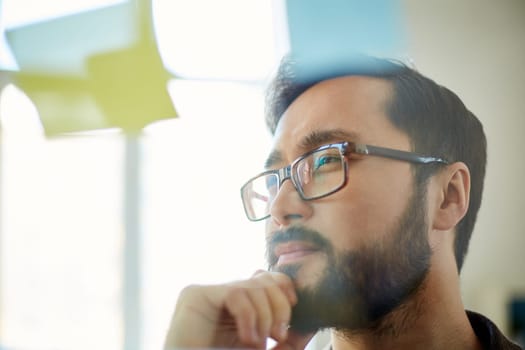 Pensive businessman looking at reminder in office