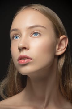 Beautiful face of young blonde woman with blue eyes and clean fresh skin close up. Youth and skin care concept