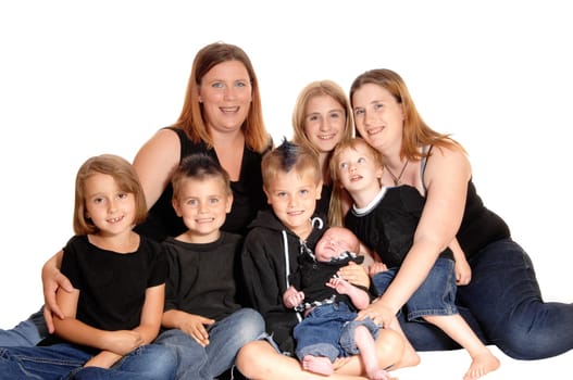 A big family of eight people sitting together on the floor in the studio,.four boy's and two girls, isolated for white background..