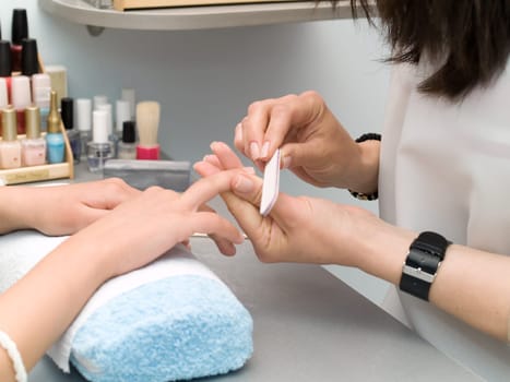 Girl fingernails being manicured.