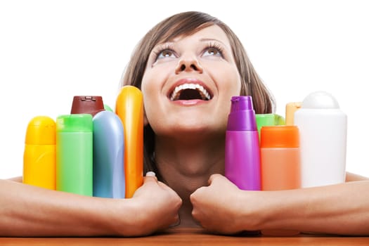 Young woman trying to choose which shampoo to buy, isolated on white background