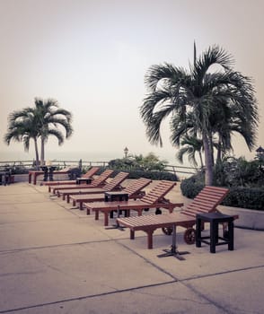 Wooden beach chairs at swimming pool in vintage style color