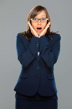Businesswoman expressing surprise isolated on gray background