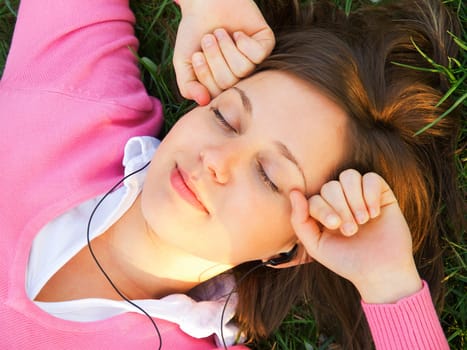 Woman listening to music on the grass