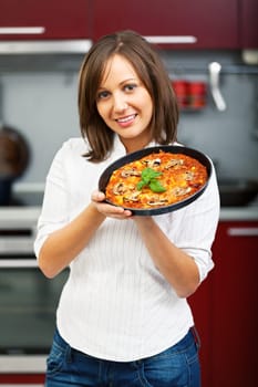 Young woman preparing homemade pizza - just after baking it