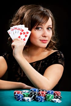 Young woman holding gambling chips on black background