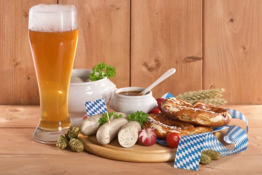 White sausage breakfast with sausages,pretzels,white beer and sweet mustard on wood substrate