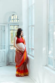 Indian picture on woman hands and pregnant belly with henna tattoo  on white room background