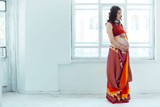 Indian picture on woman hands and pregnant belly with henna tattoo  on white room background