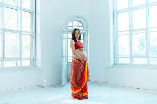 Indian picture on woman hands and pregnant belly with henna tattoo  on white room background
