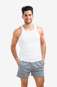 Portrait of a athletic young man holding a water bottle, isolated over a gray background