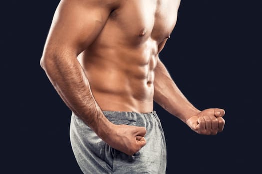 Handsome and sexy muscular man, isolated over gray background
