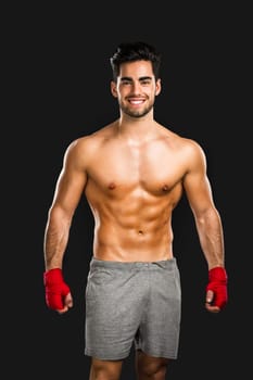 Handsome and sexy muscular man, isolated over gray background