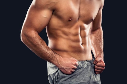 Handsome and sexy muscular man, isolated over gray background