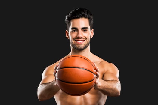 Portrait of a handsome basketball player, isolated over a gray background