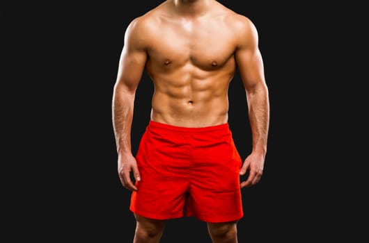 Handsome and sexy muscular man, isolated over gray background