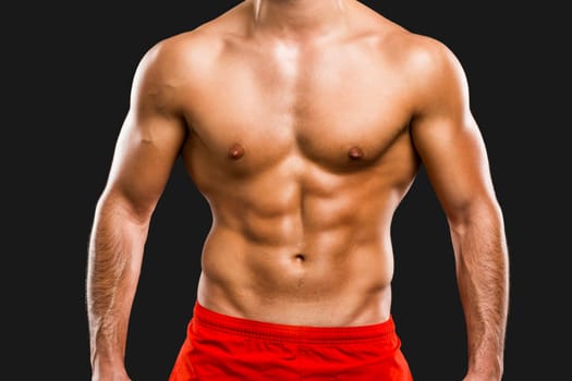 Handsome and sexy muscular man, isolated over gray background
