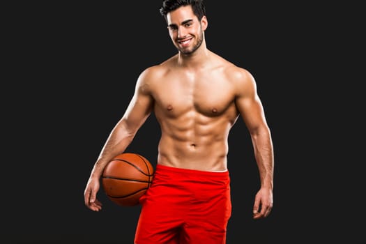 Handsome and sexy muscular man, isolated over gray background