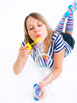 Girl blowing bubbles, isolated on white