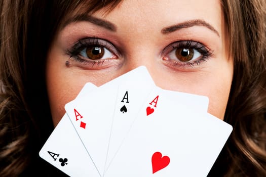 Young woman holding four aces in front of her face