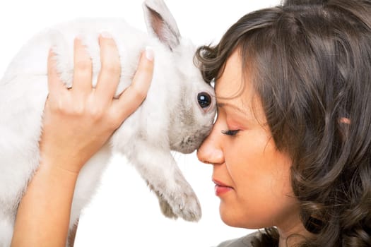 Young woman kissing a rabbit in her hands isolated on white background