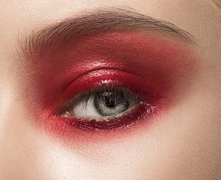 Close-up shot of female eye with red makeup