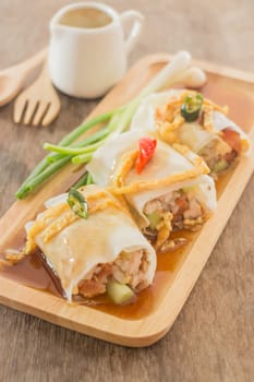 Spring rolls with vegetables and chicken on wooden plate, stock photo