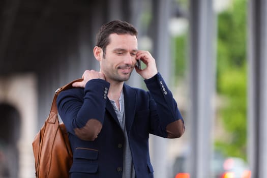 Young attractive man using smartphone in Paris, France