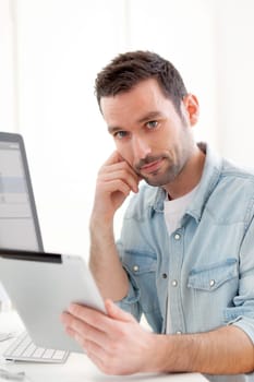 View of a Young relaxed man using tablet at home
