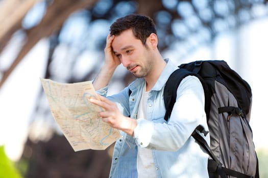 Young attractive tourist reading map in Paris, France