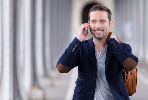 Young attractive man using smartphone in Paris, France