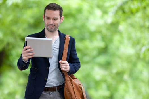 View of a Young attractive man using tablet in Paris, France
