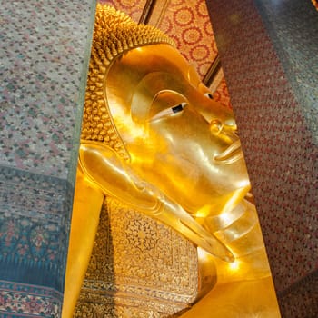 Face of Reclining Buddha gold statue in Wat Pho buddhist temple, Bangkok, Thailand