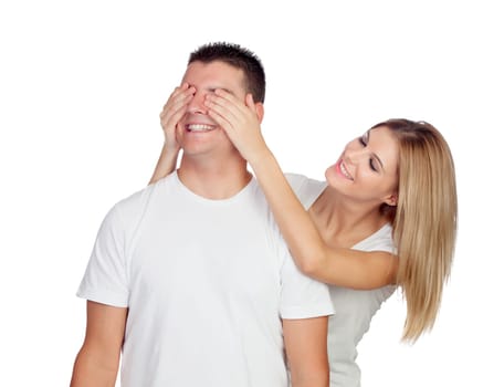 Smiling girl covering his boyfriend's eyes to surprise him isolated on a white background