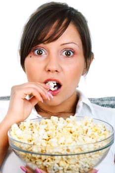 Young woman eating popcorn while watching scary movie isolated on white background