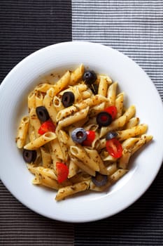 Penne with cherry tomatos and black olives fried with fresh herbs