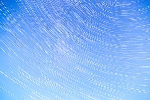 Star Trails streaking across a Blue Sky.