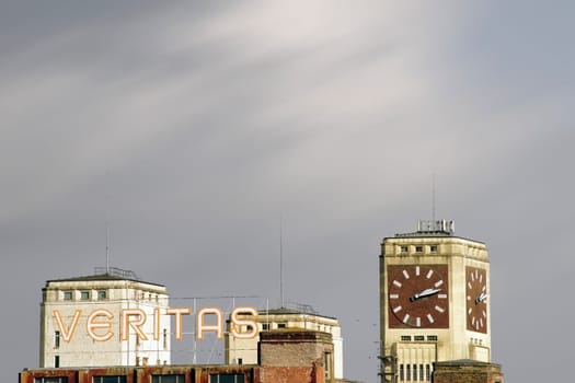 Wittenberge,Germany – February 25,2015: The top of the clock tower and the logo on an industrial building of the former sewing machine factory Veritas/Singer on February 25,2015 in Wittenberge.